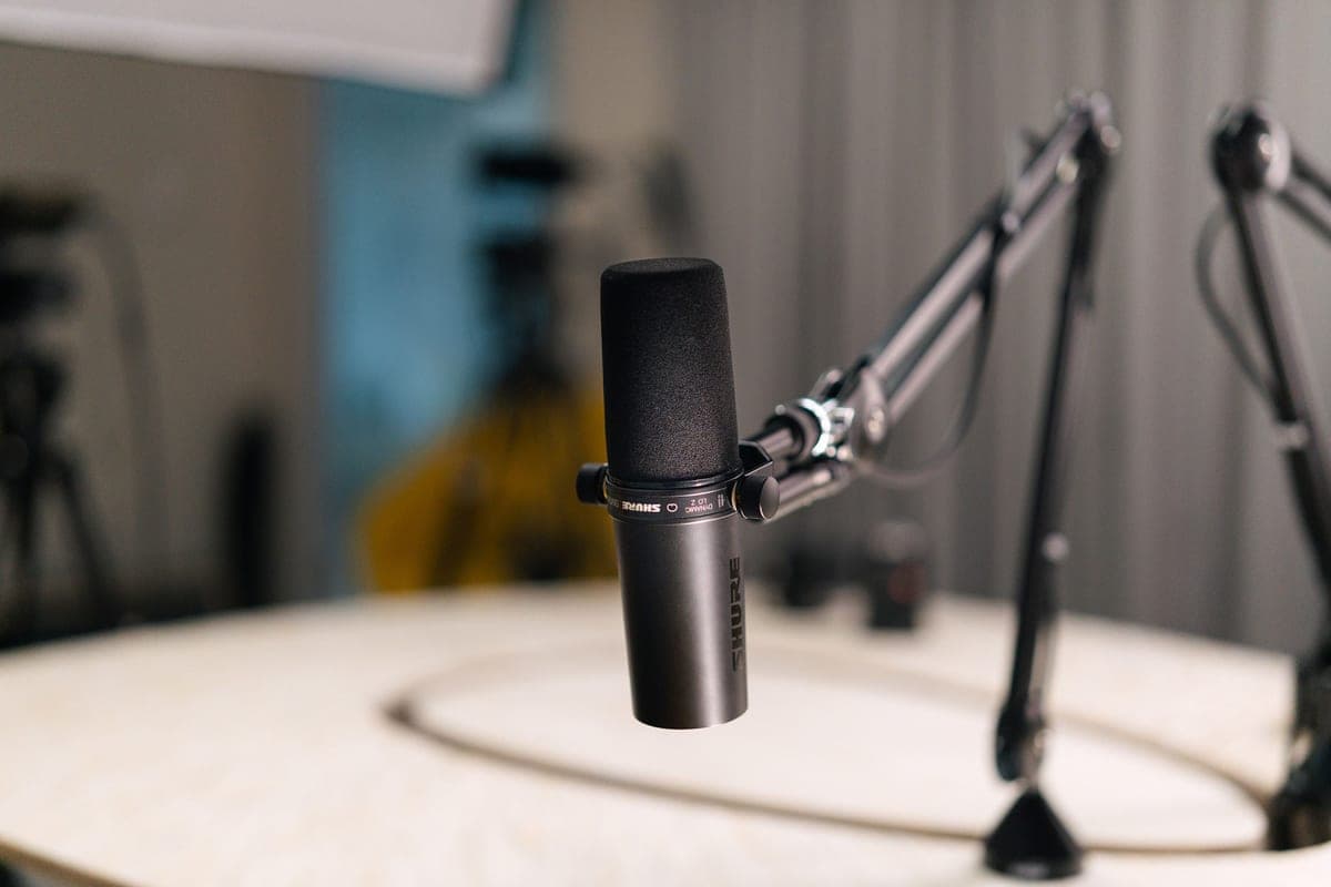 A spring-loaded microphone boom arm clamped to the edge of a desk